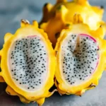 sliced yellow dragon fruit on white plate with mint